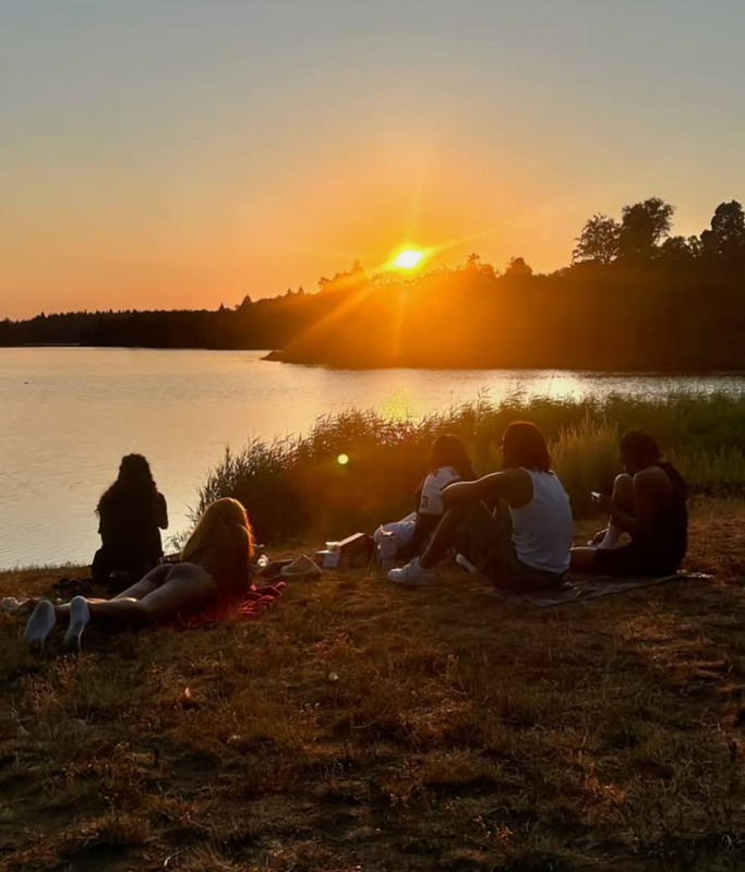 Friends enjoying a summer sunset together by the lake